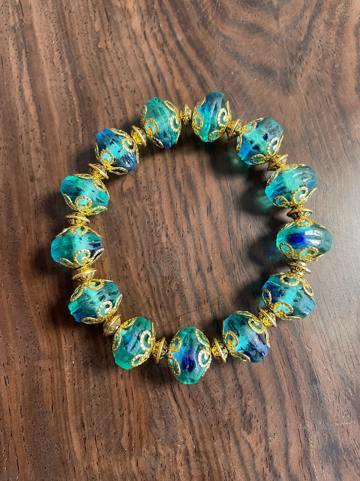 Groene glazen kralenarmband met blauwe wirlels