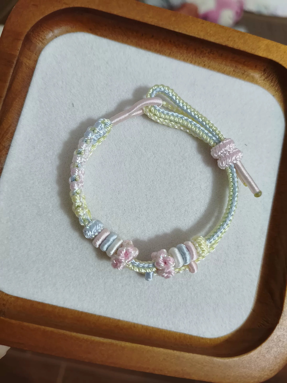 Pulsera de cordón trenzado a mano con flores en degradado pastel