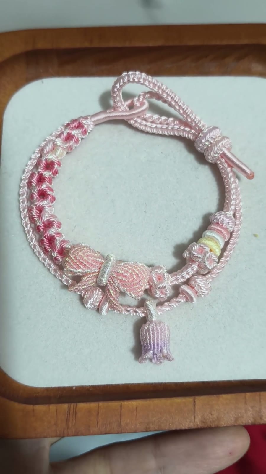 Bracciale in cordino intrecciato con sfumatura rosa e fiori