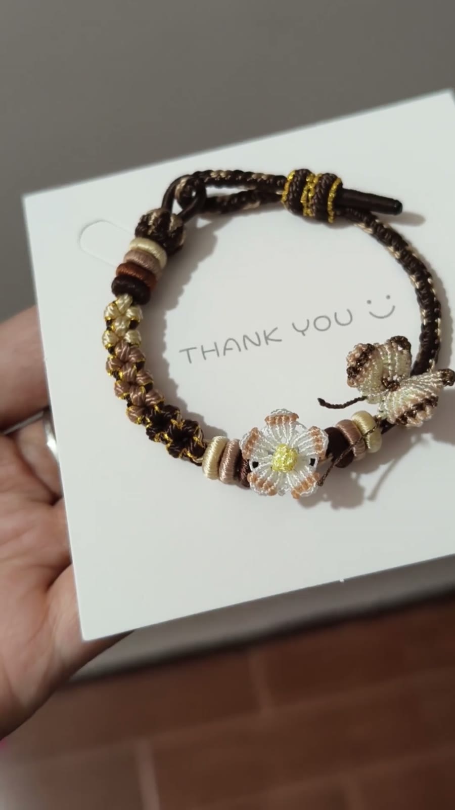 Handflätat armband i snöre svart guld blomma