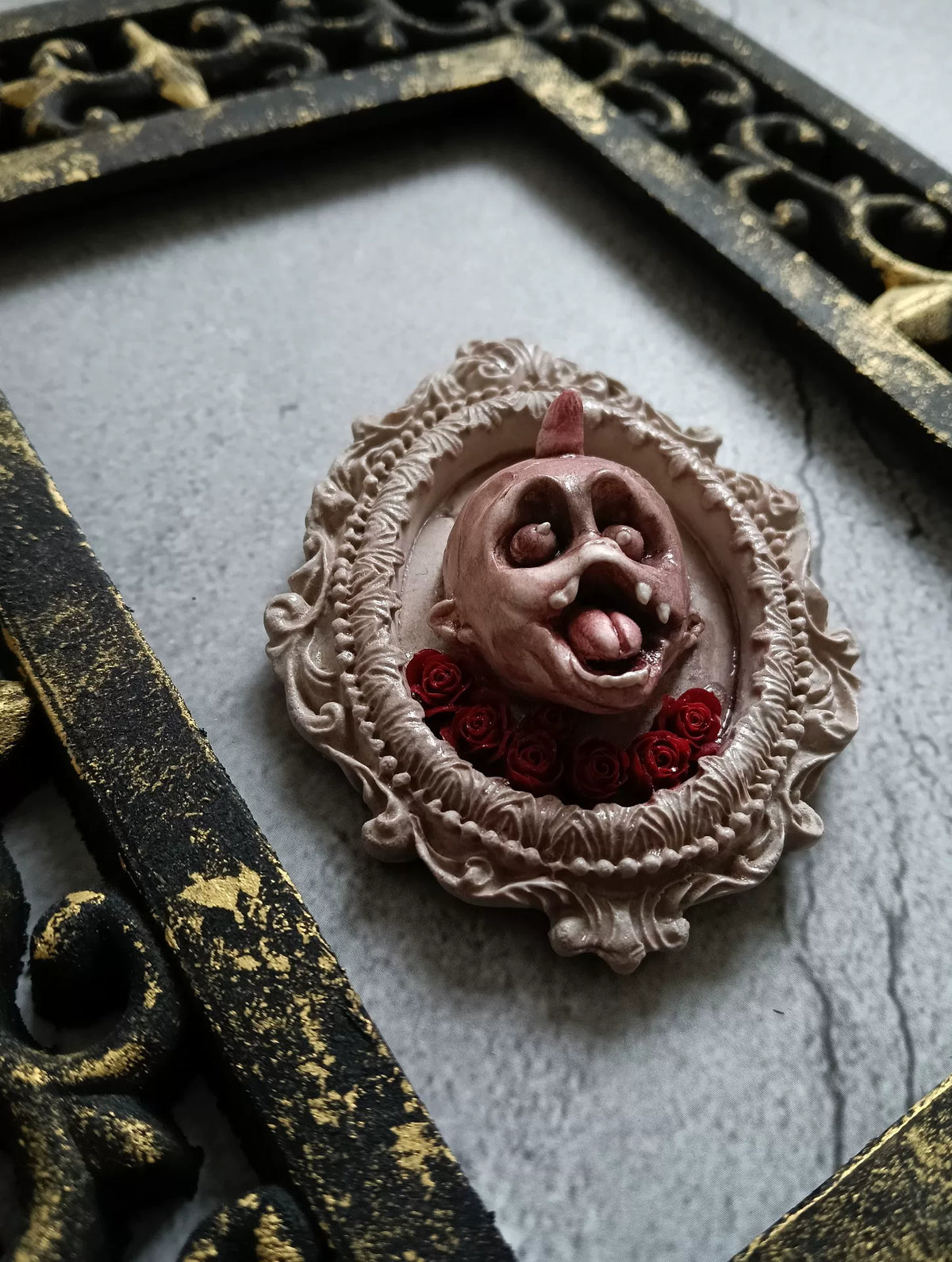 Broche de cabeza de demonio gótico con rosas rojas
