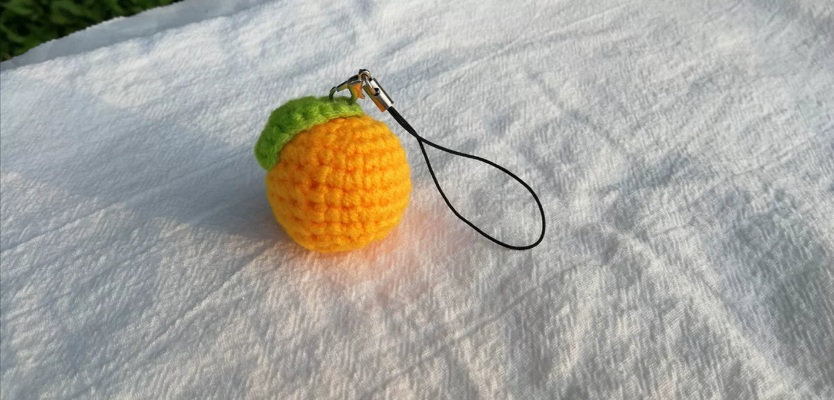 Virkad mandarin-nyckelring med grönt blad