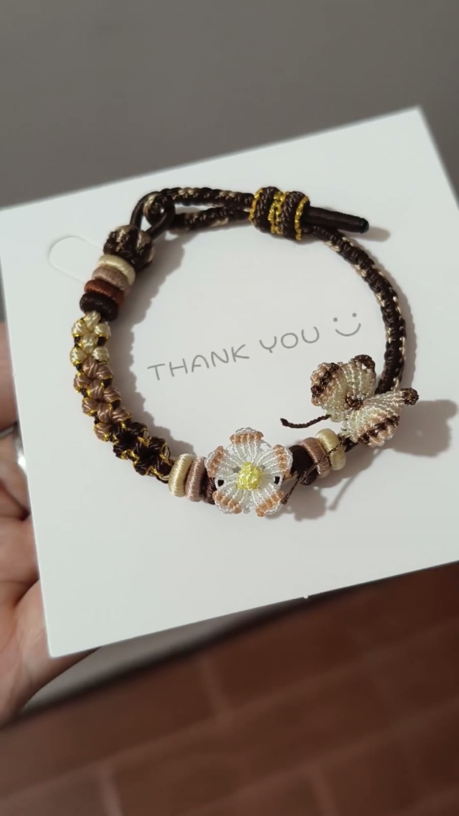 Handflätat armband i snöre svart guld blomma