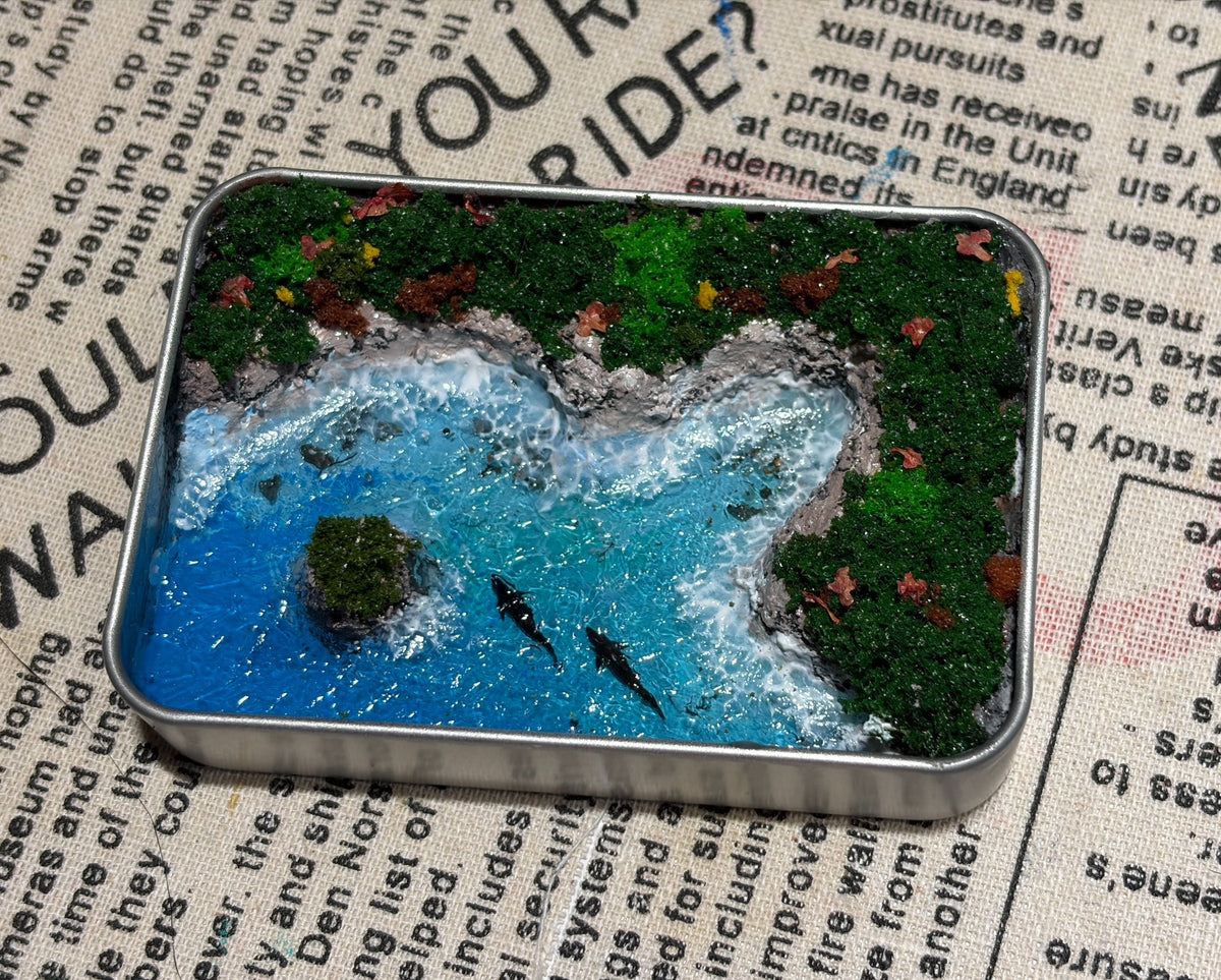 Miniatur-Diorama mit blauem Meer in der Metalldose