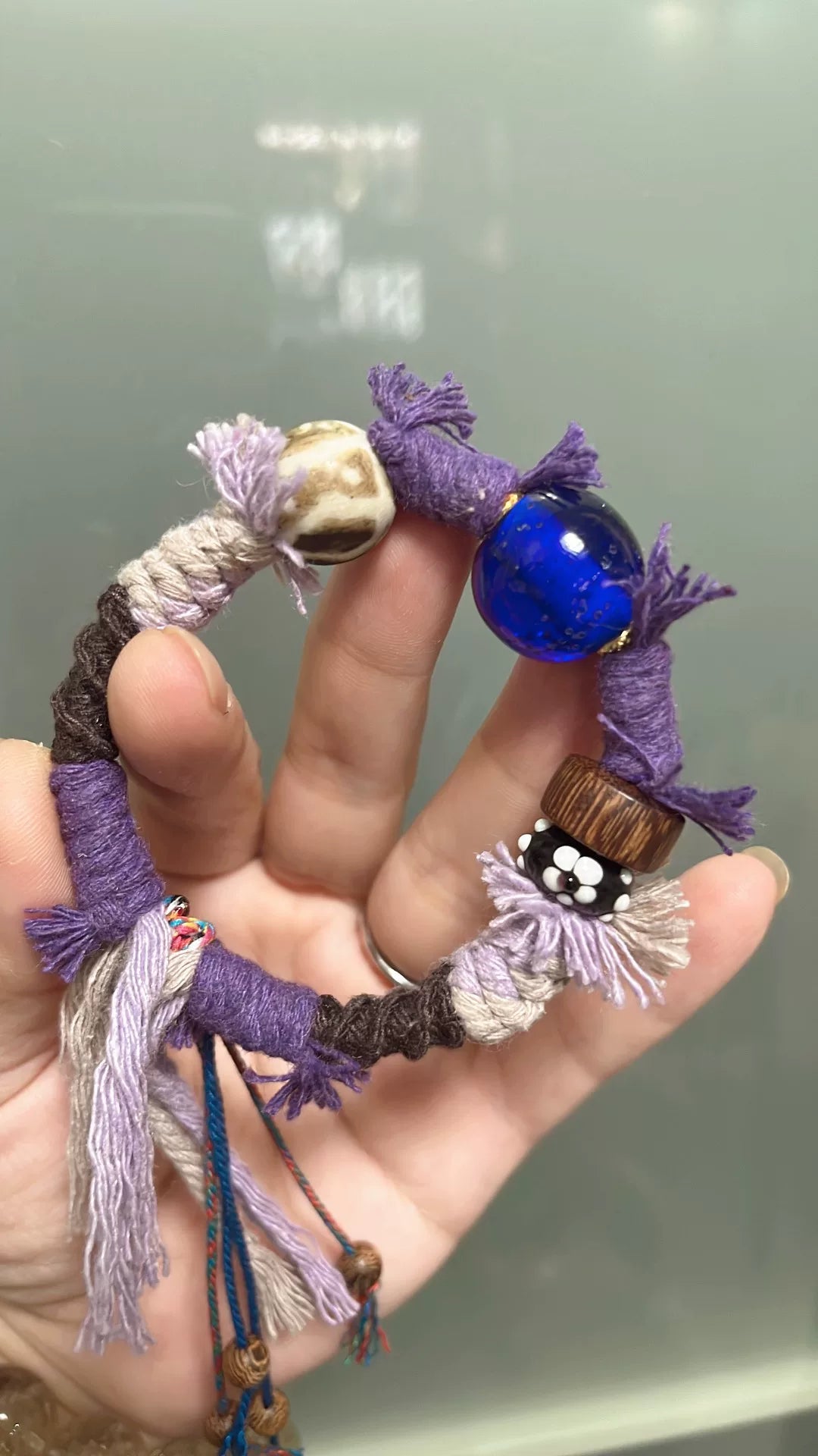 Handgemaakte gevlecht paars koord armband met blauwe glaskraal