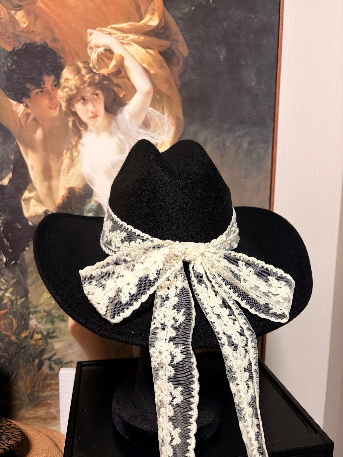 Cappello nero a tesa larga con fiocco in pizzo bianco