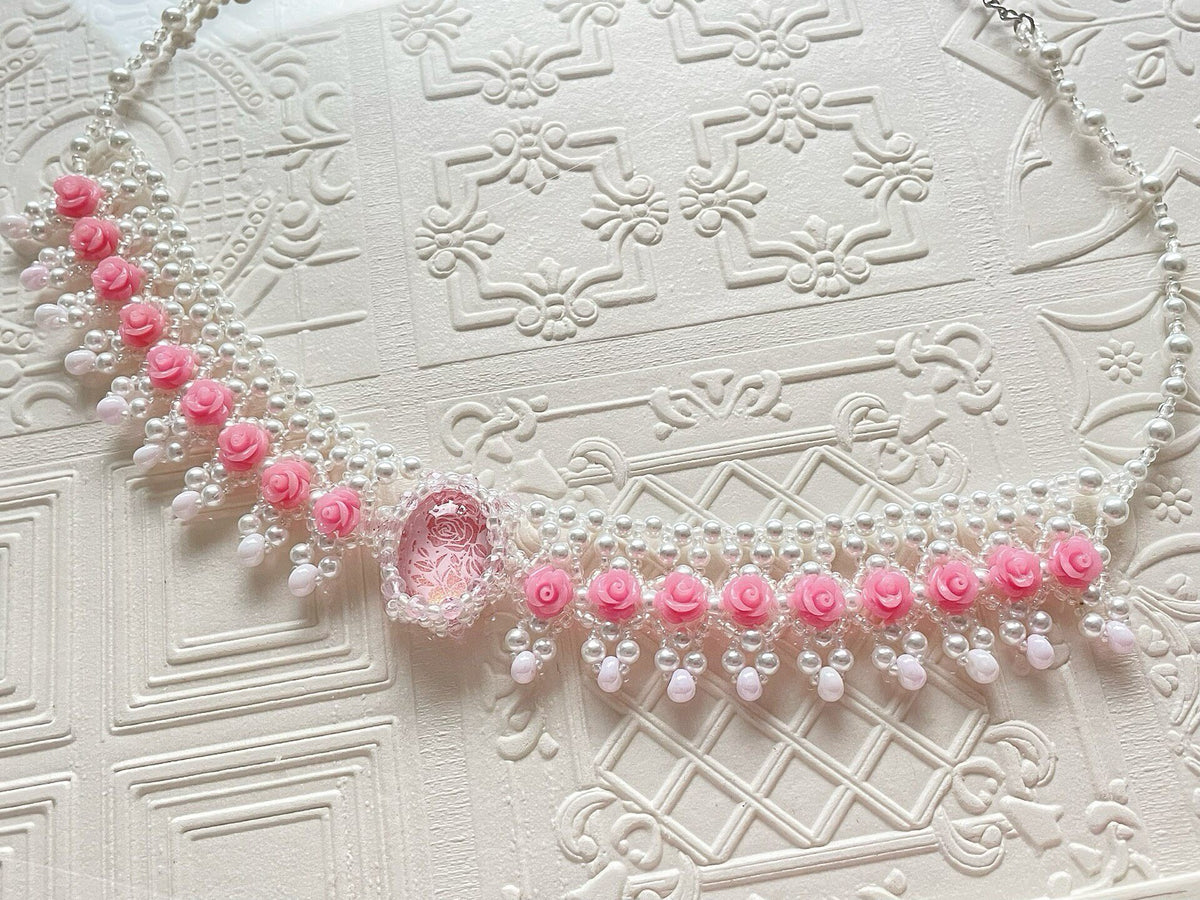 Roze kralenketting met rozenbloemen