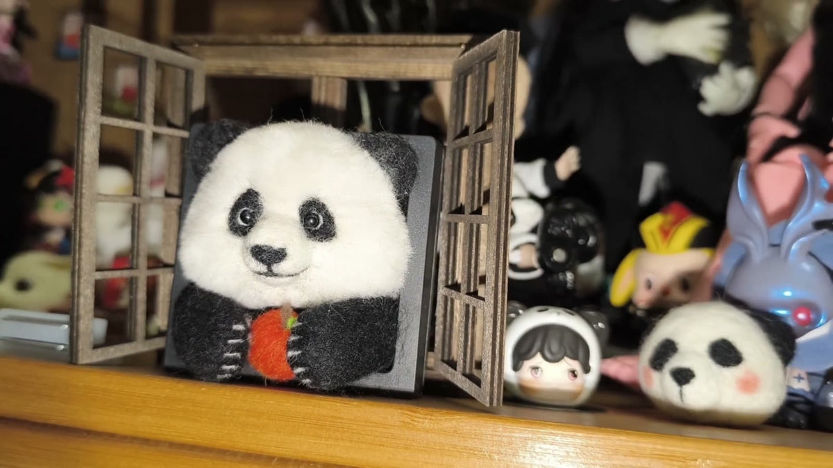 Handgjord ramdekor med panda i ullfilt som äter äpple