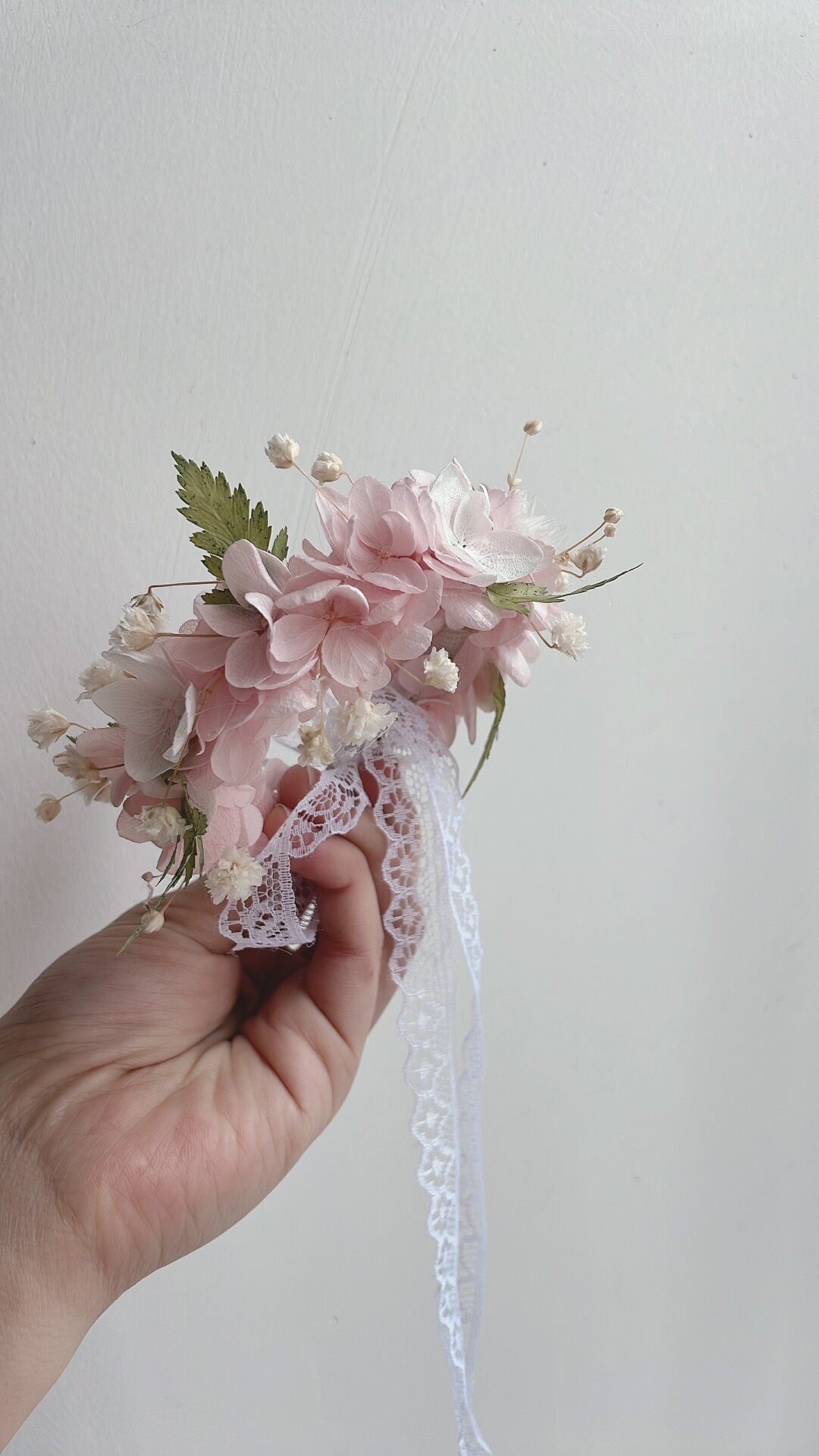 Corsage da polso da sposa con ortensie rosa conservate
