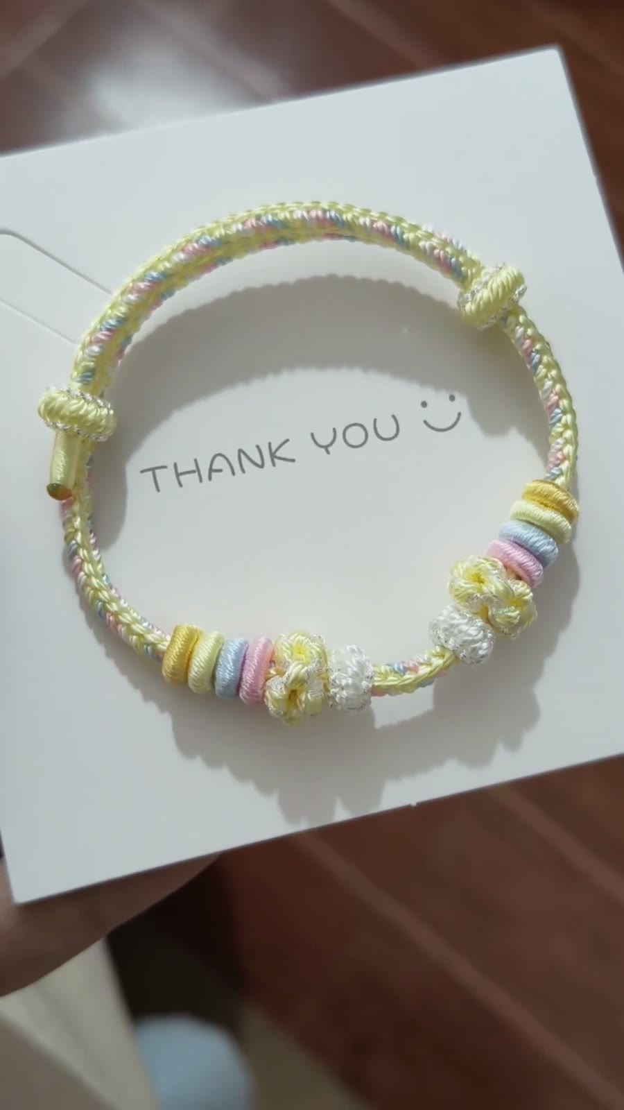 Handgeflochtenes Regenbogen-Kordarmband mit Blumenanhängern