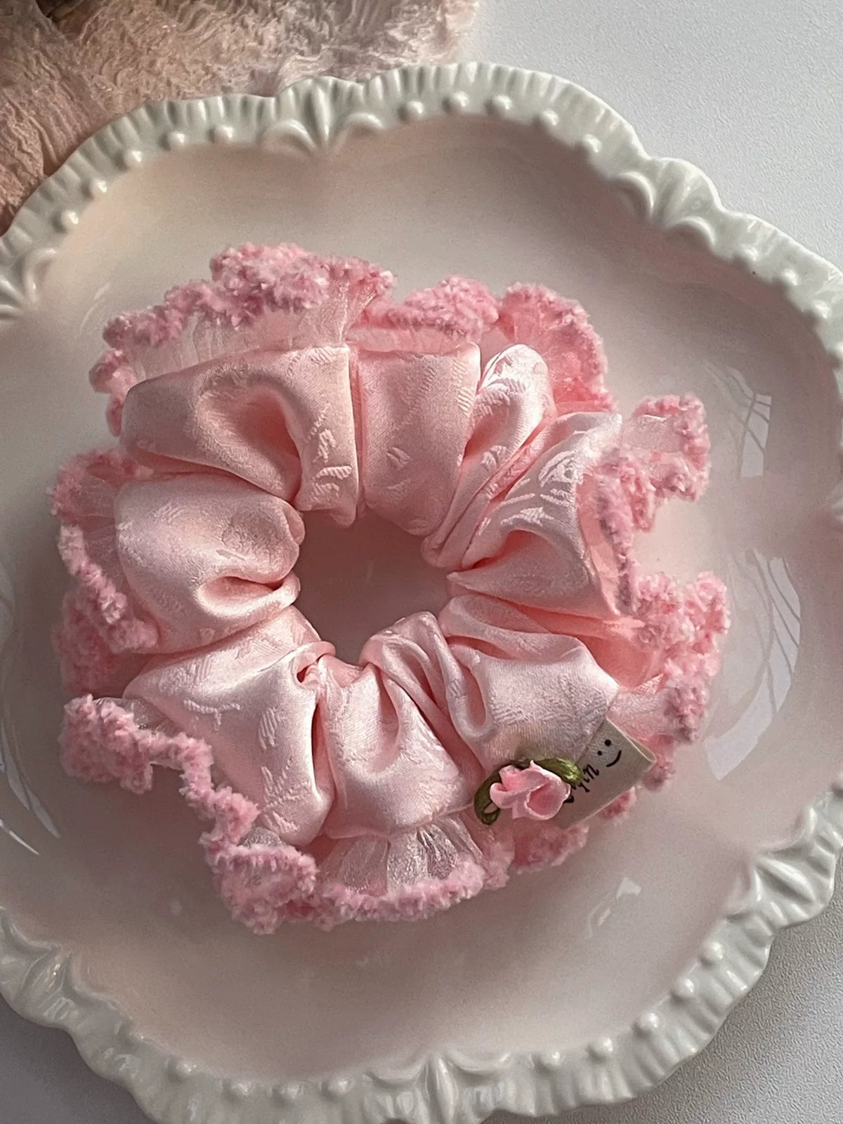 Rosa hårsnodd i siden med siden och ros