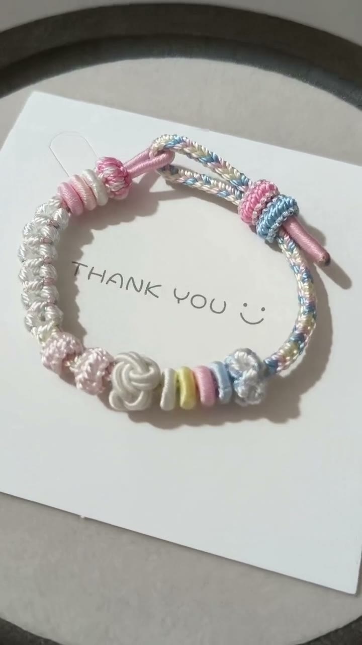 Pulseira de Cordão Tecida à Mão com Gradiente Pastel e Nós em Flor