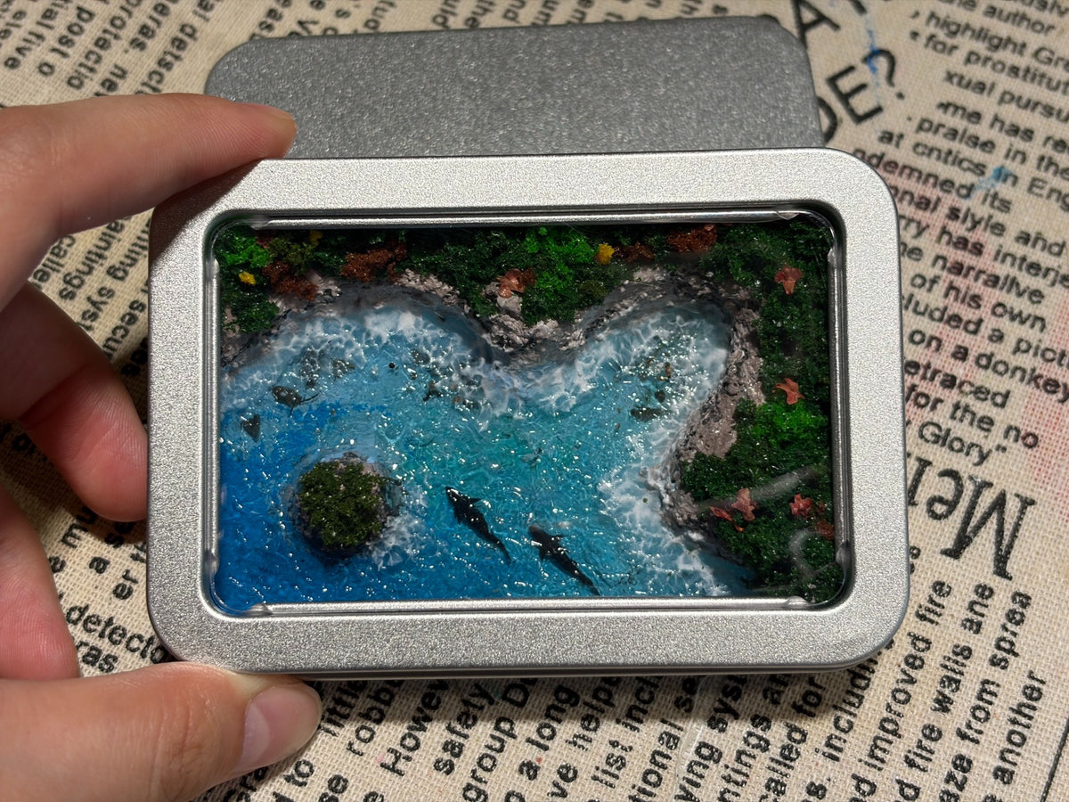 Miniatur-Diorama mit blauem Meer in der Metalldose