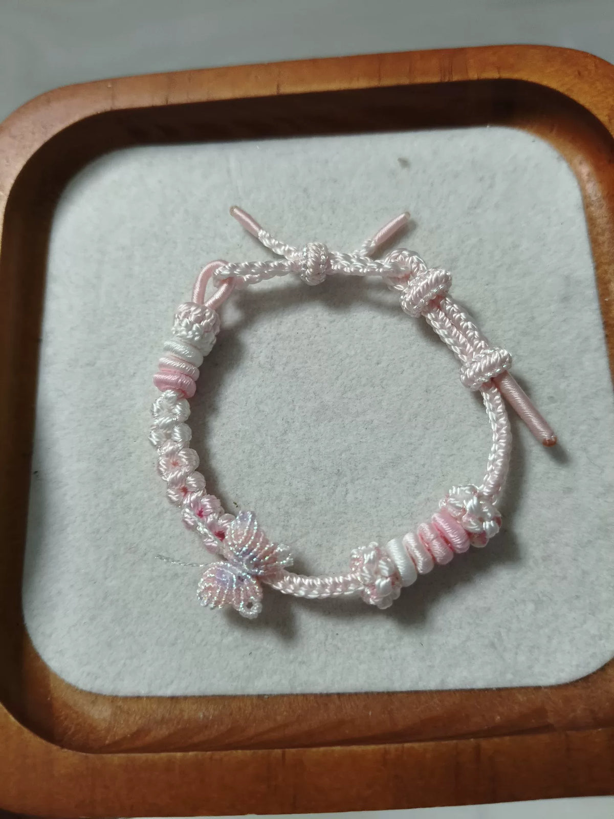 Pulseira Trançada à Mão Rosa e Branco com Pingente de Borboleta
