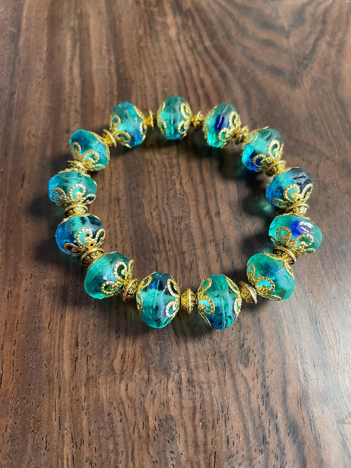 Groene glazen kralenarmband met blauwe wirlels