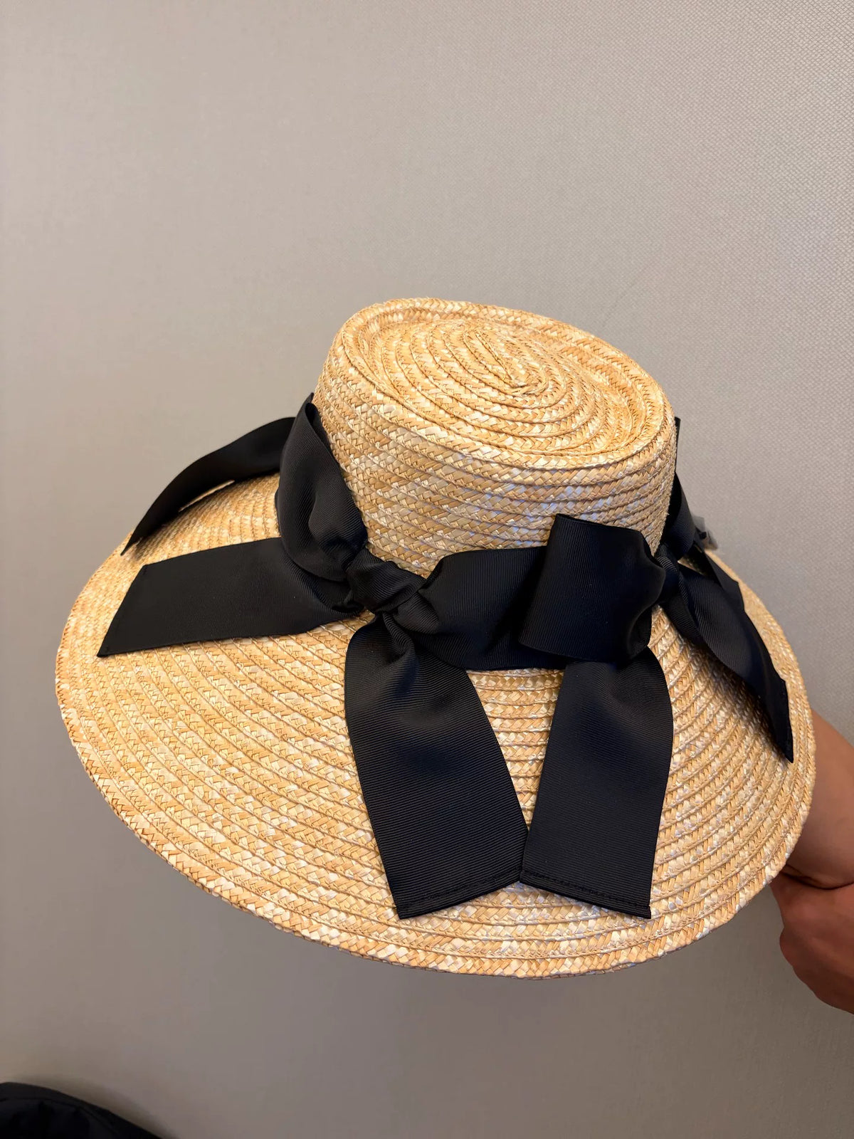 Chapeau de soleil à large bord en paille tissée avec nœud noir