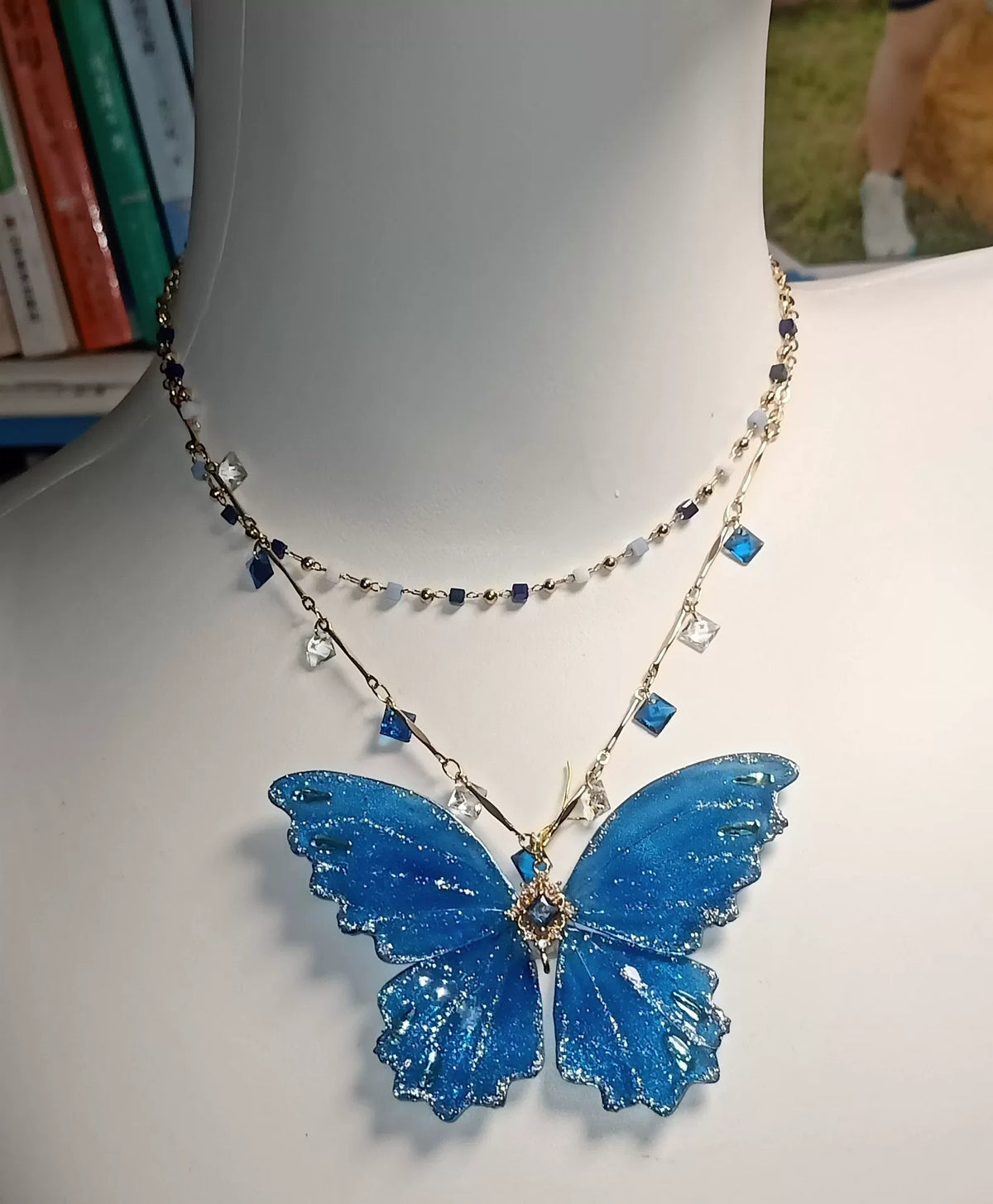 Collar de mariposa en laca azul y purpurina