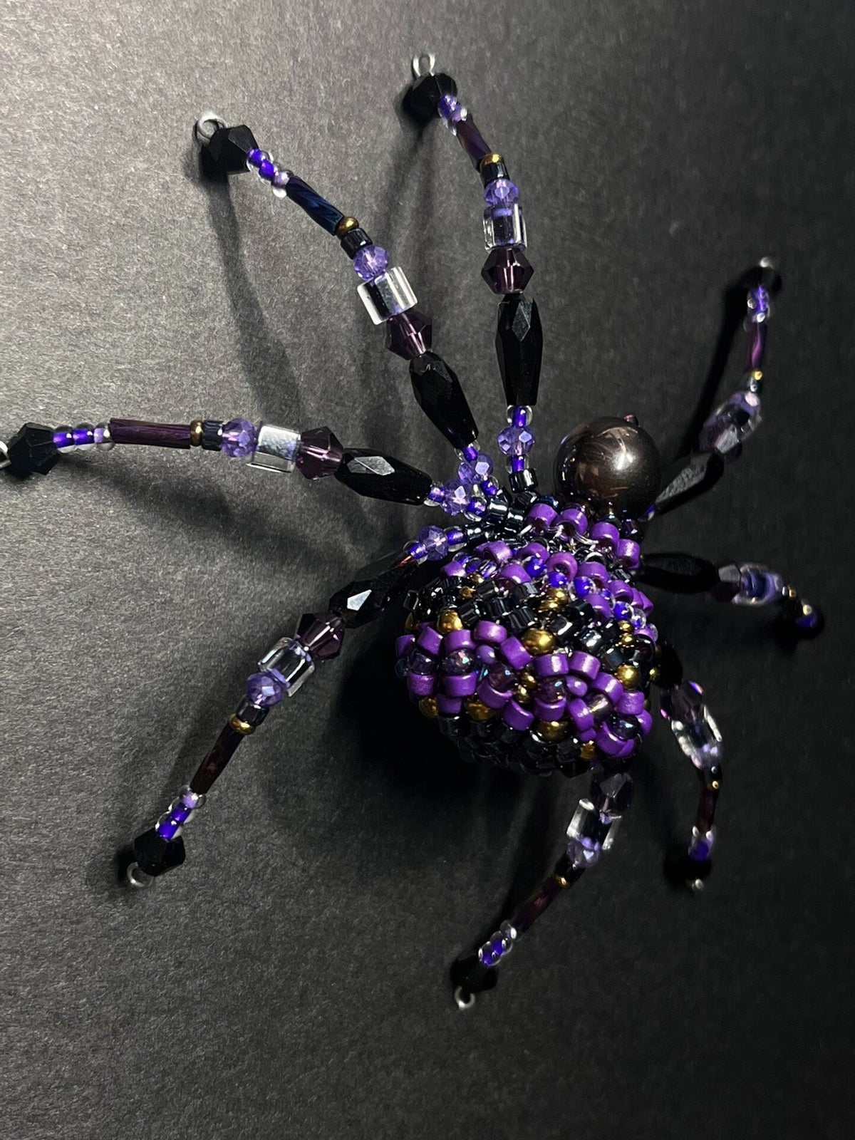 Ornamento a forma di ragno in perline nero e viola