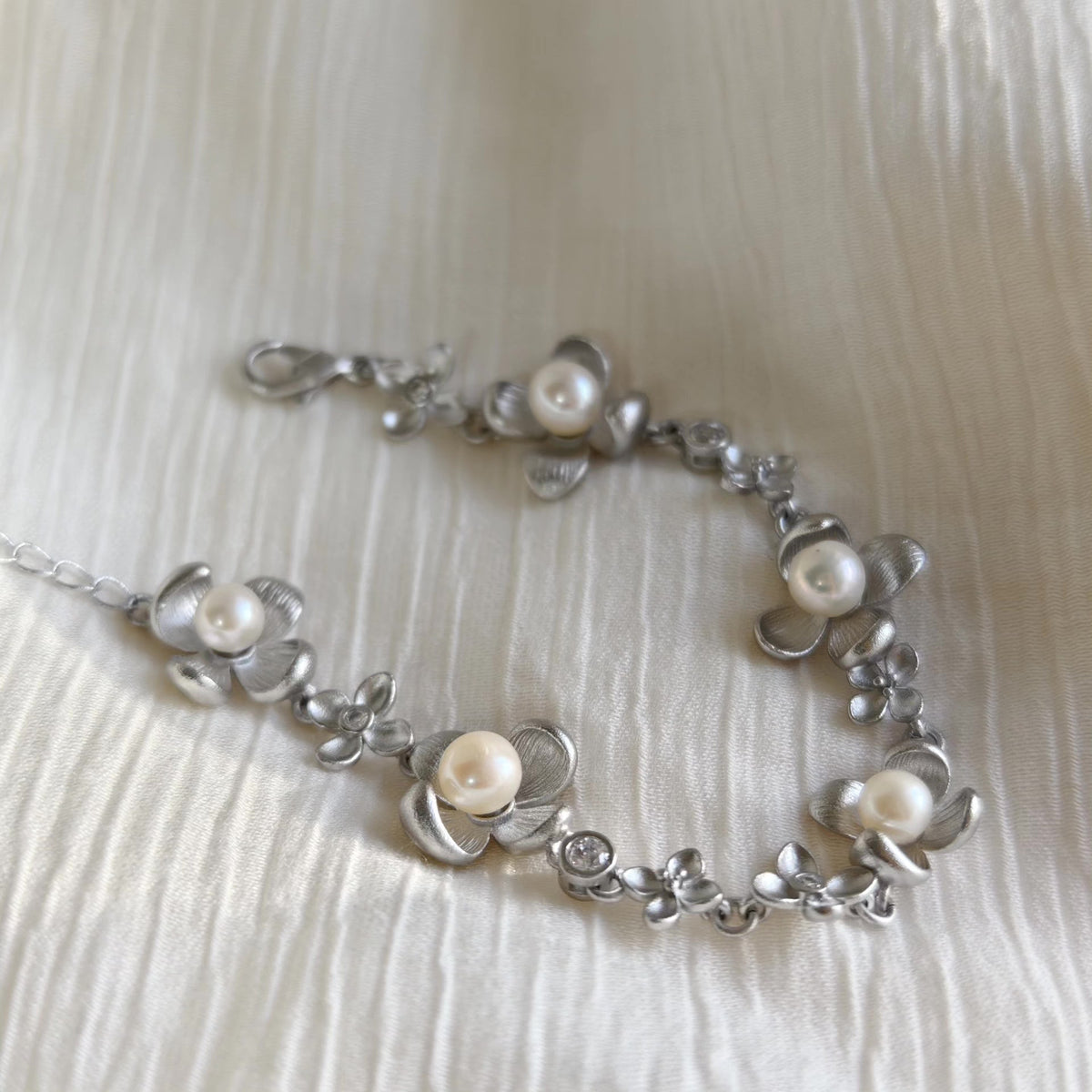 Braccialiale floreale in argento spazzolato con perle naturali