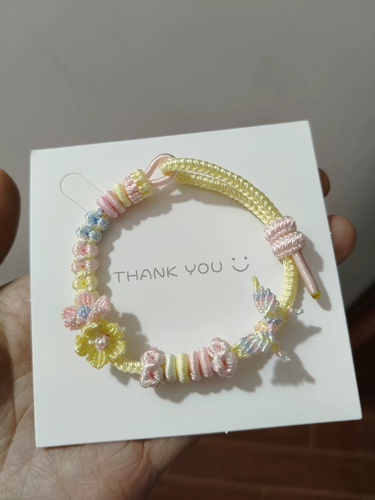 Handgewebtes Armband in Rosa-Gelb-Blau-Gradient mit Schmetterlings-Charm
