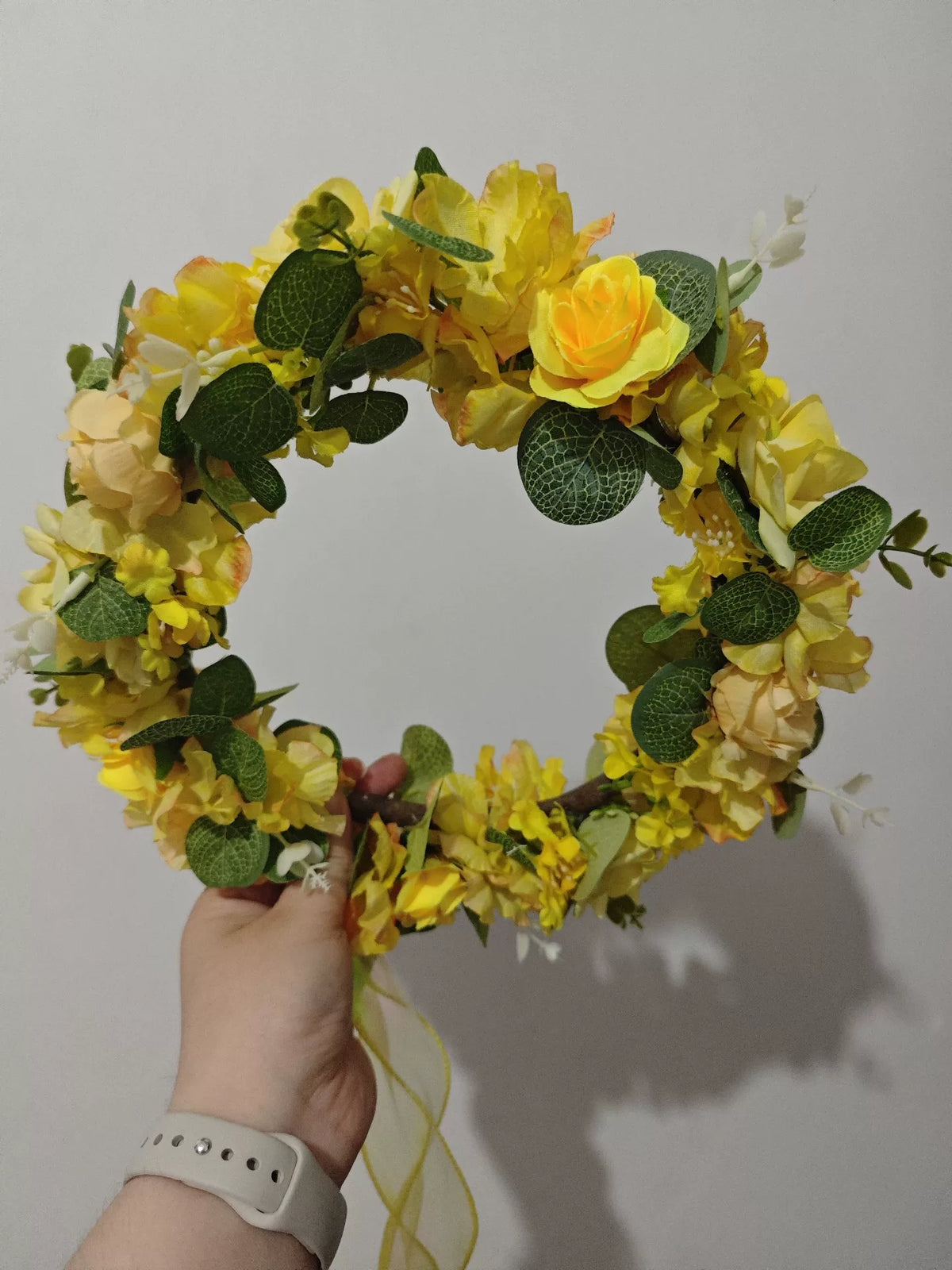 Blomsterkrans med guldgula rosor i skogsdesign