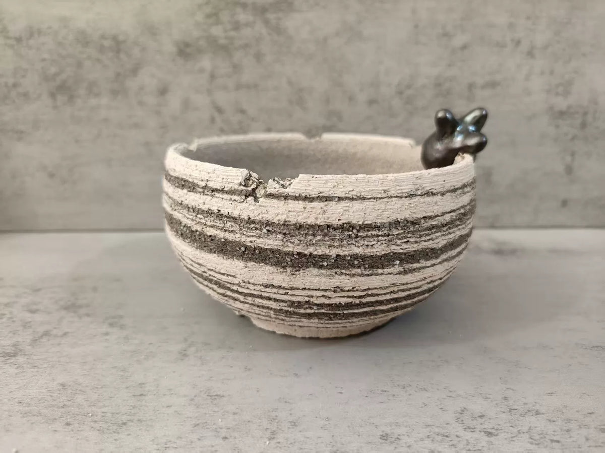 Handgakte gestreepte keramische schaal met dierfiguur