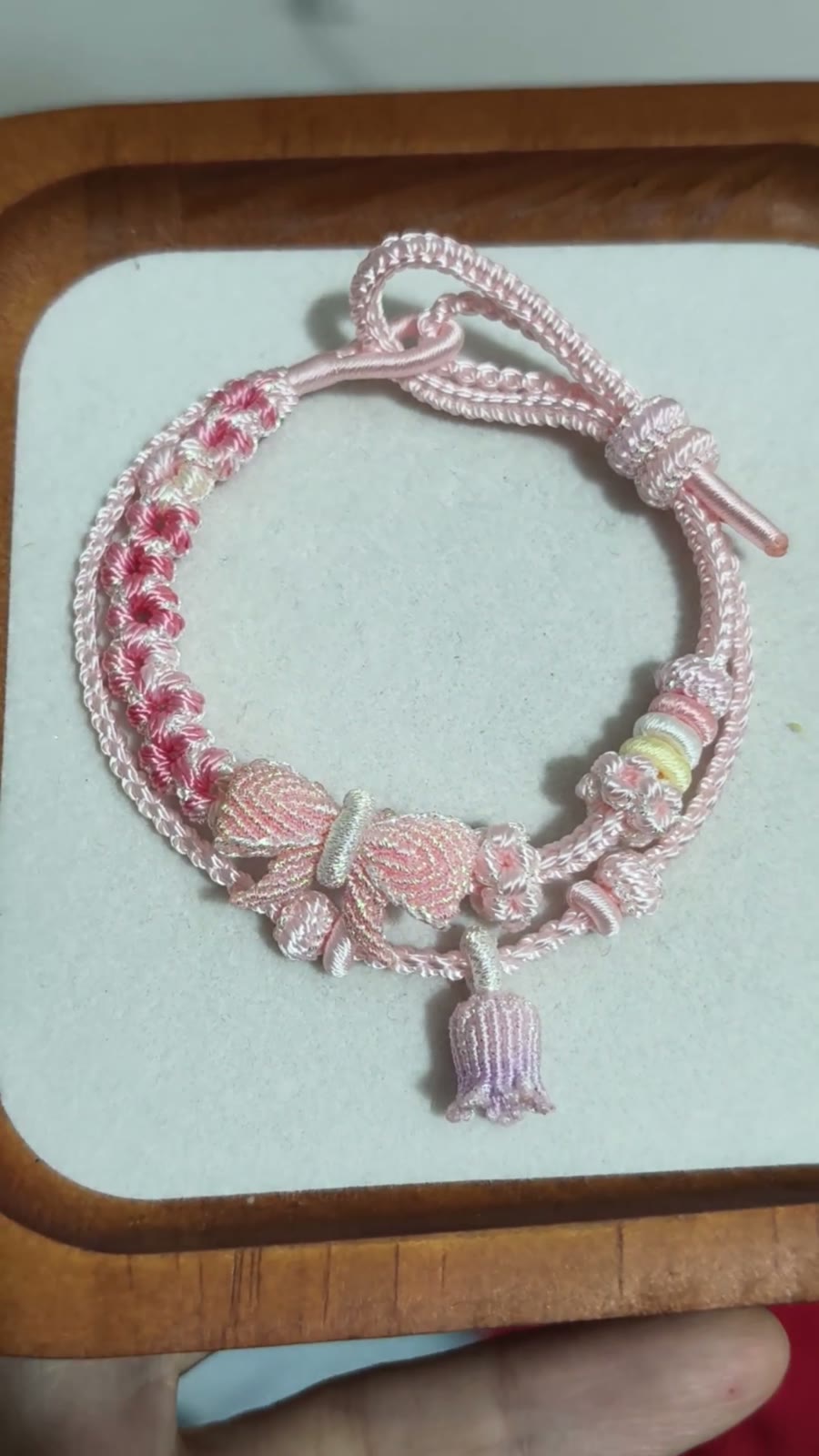 Bracciale in cordino intrecciato con sfumatura rosa e fiori