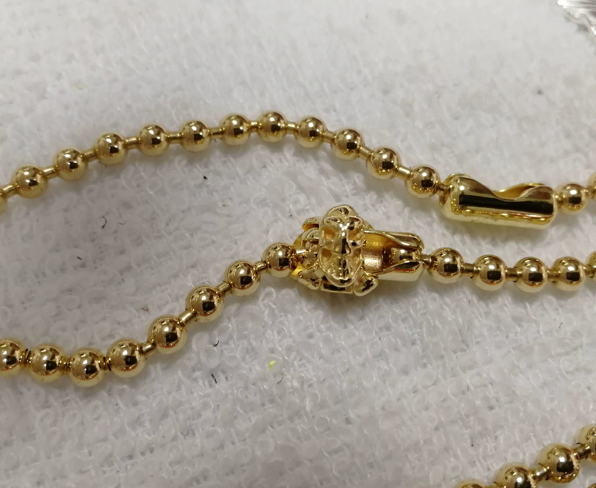 Chaîne de perles dorées avec fermoir crâne