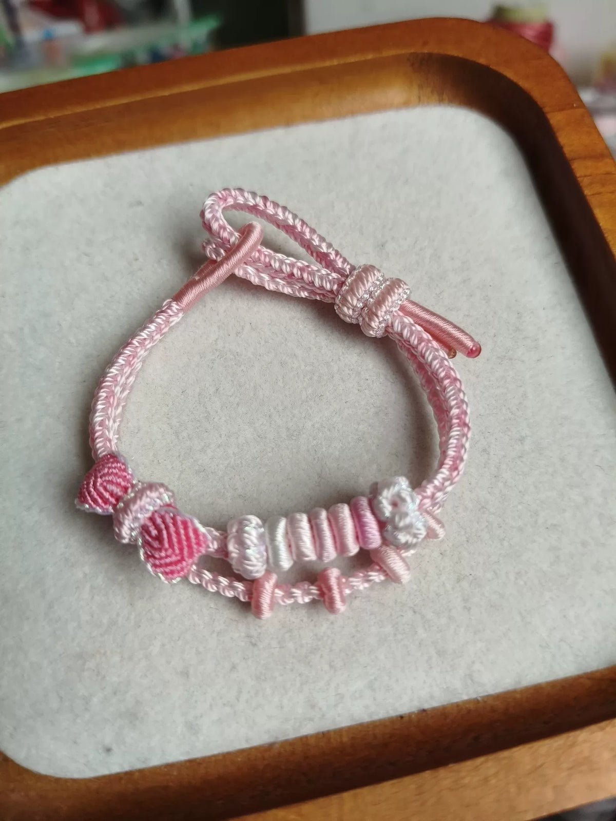 Handgelochten armband in roze-wit verloop met strik