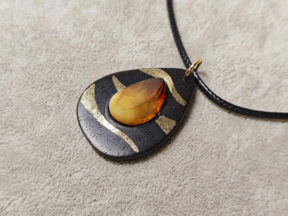 Pendentif larme en bois de santal noir et cire d'ambre