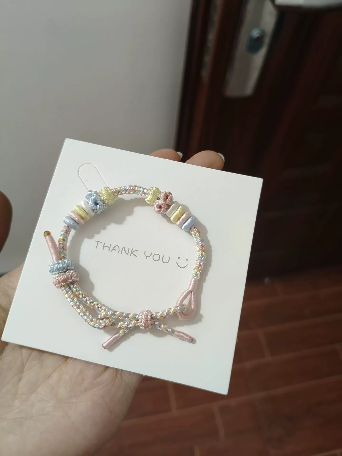 Braccialetto intrecciato arcobaleno con nodi a fiore
