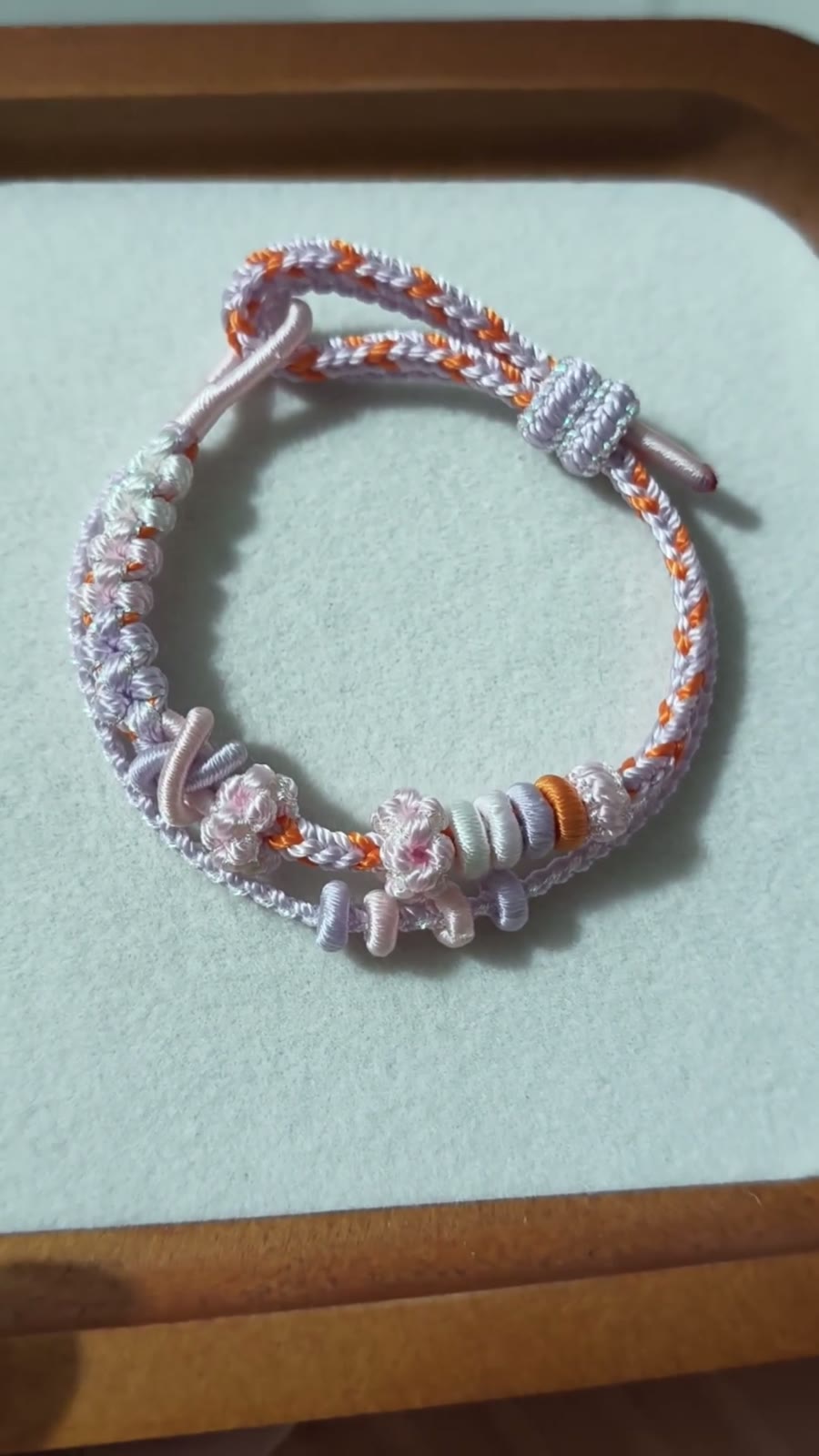 Handvävt armband i snöre vit och orange blomma