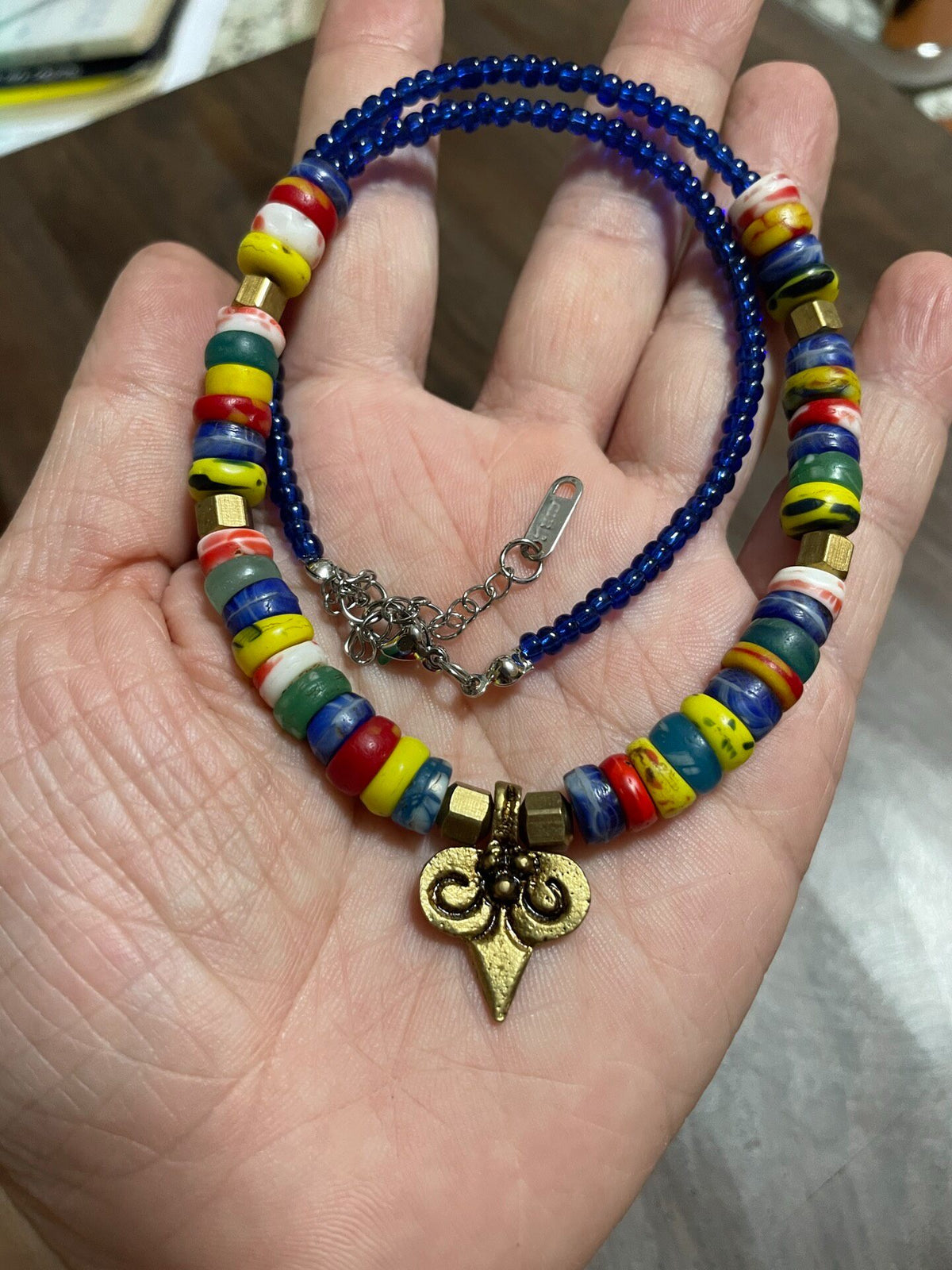 Collier en perles de verre multicolores et pendentif en laiton