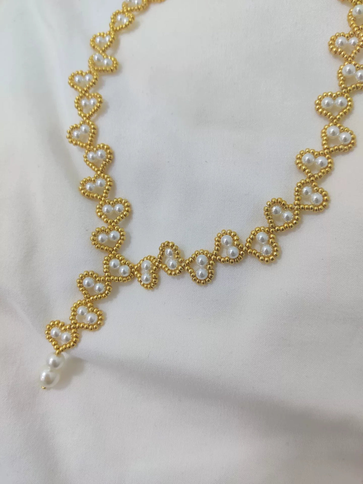 Collar de corazón con cuentas doradas y perlas hecho a mano
