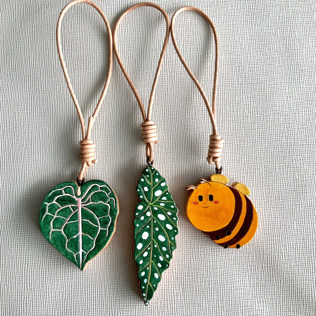 Handbeschilderde Leren Blad en Bij Charms
