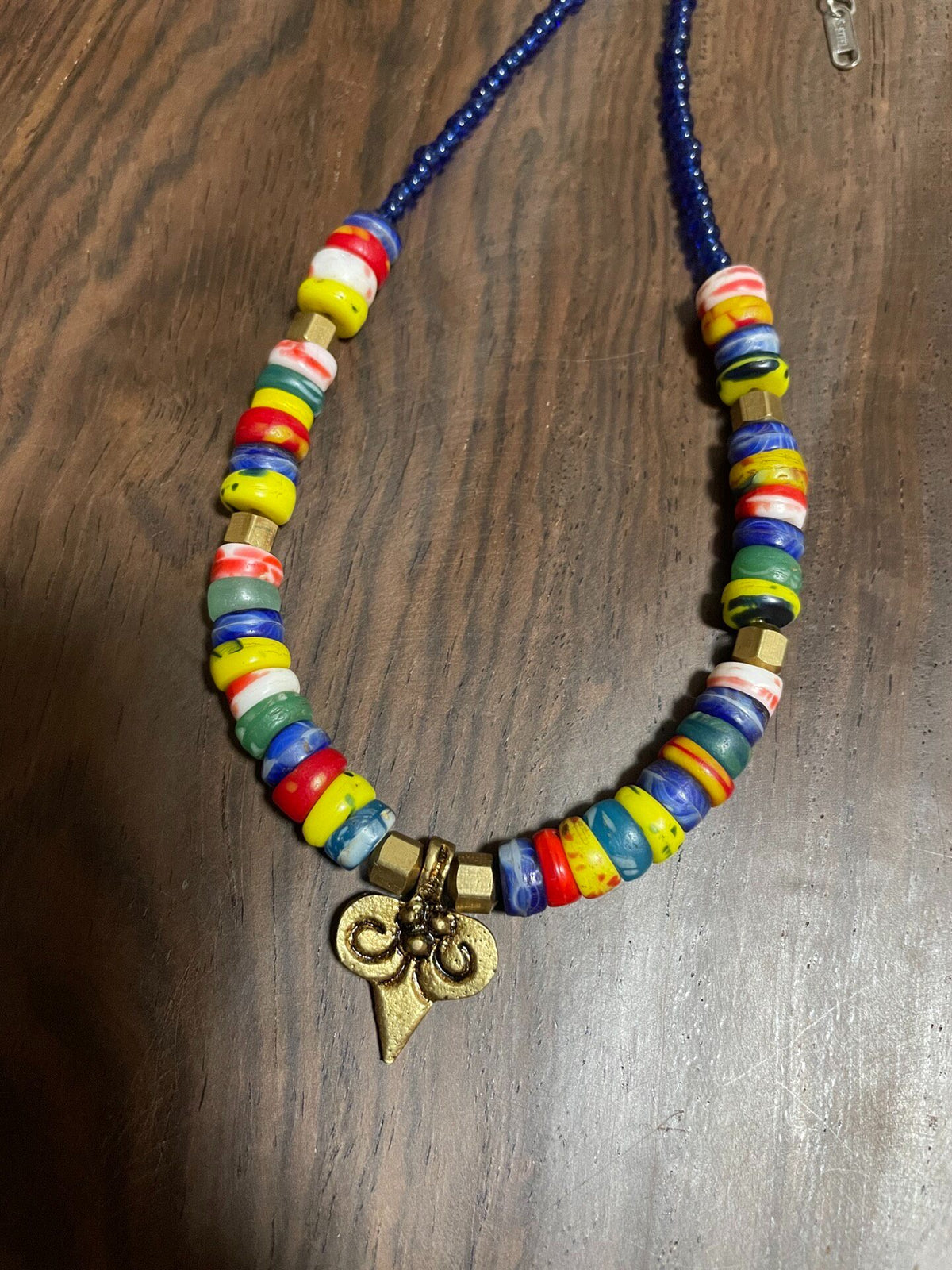 Collier en perles de verre multicolores et pendentif en laiton
