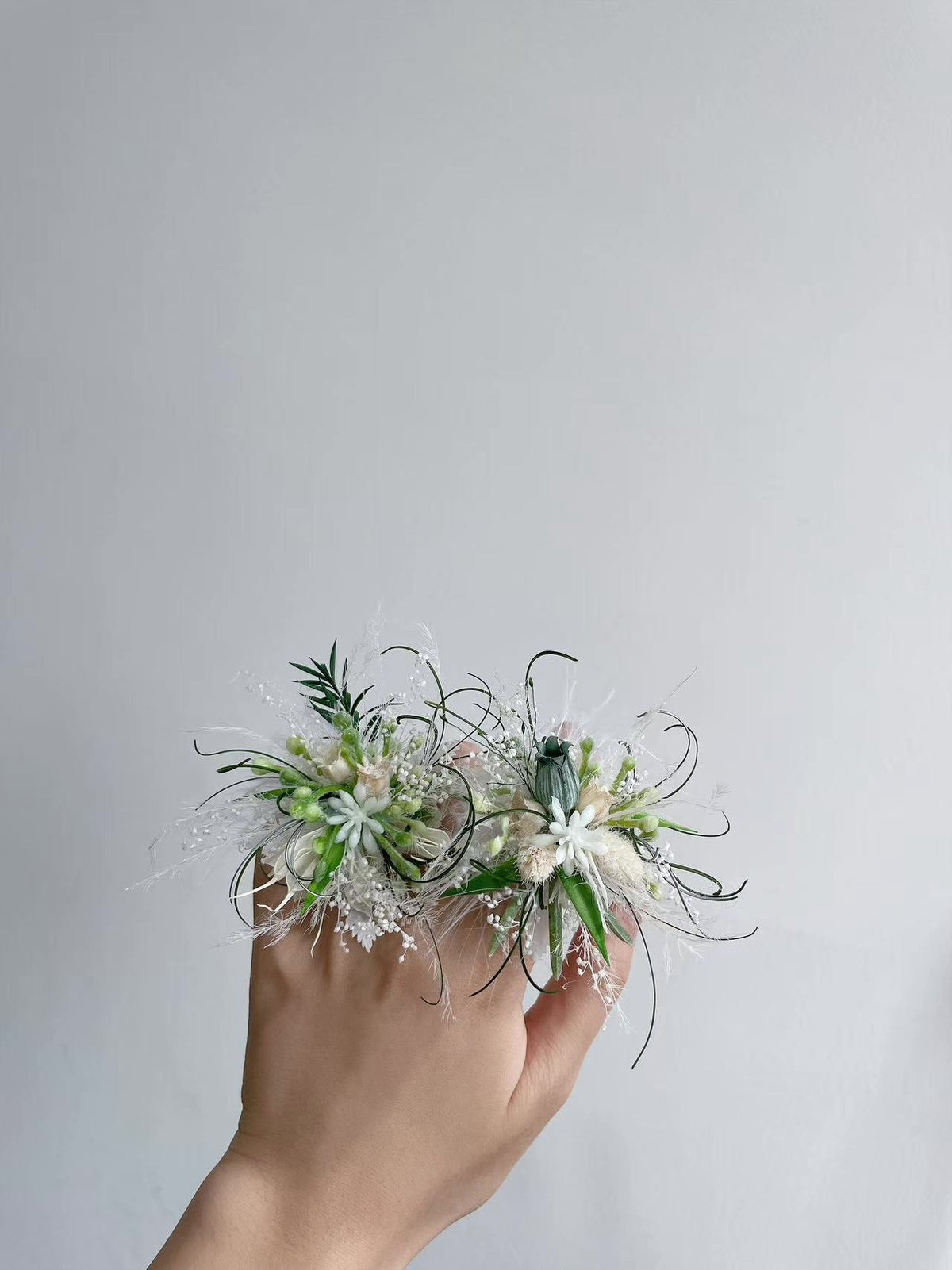 Vitaitt och gröna blomsterringar i par
